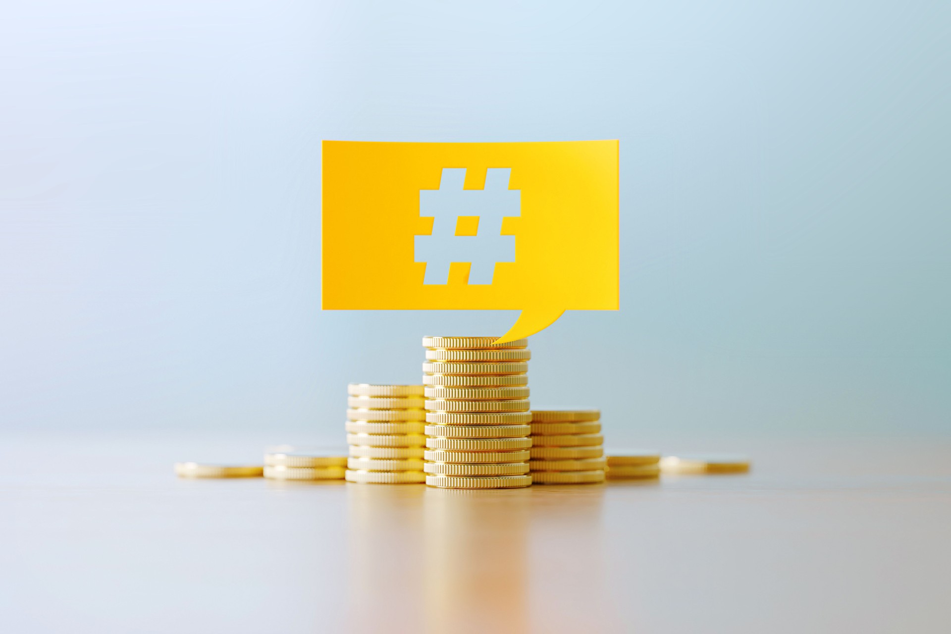 Budget Concept - Hashtag Symbol Written Yellow Speech Bubble Sitting Over Coin Stacks Before Defocused Background